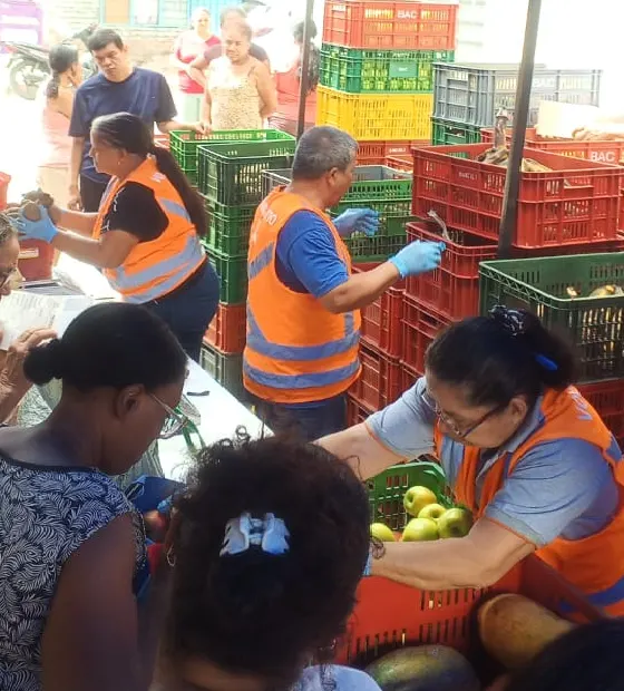 Integrantes de Zaranda con chalecos naranja clasifican alimentos durante un evento comunitario